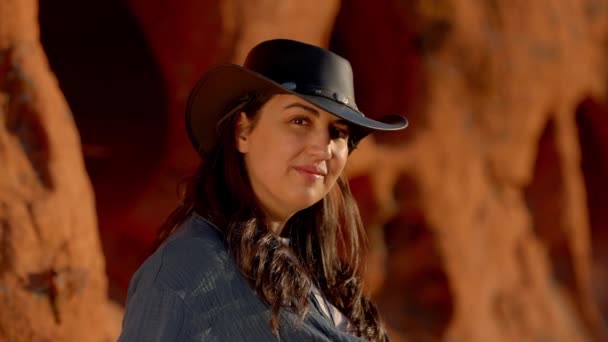 牛仔女孩在亚利桑那州沙漠中的一块红色岩石上放松 旅行摄影 — 图库视频影像