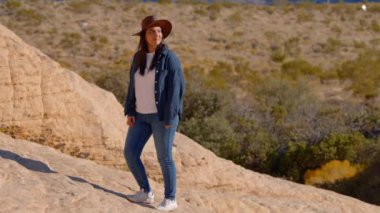 Nevada çölünde tek başına yürüyen genç kovboy kız. Seyahat fotoğrafçılığı.