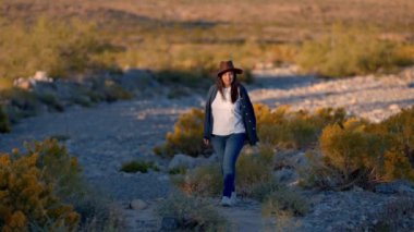 Nevada çölünde tek başına yürüyen genç kovboy kız. Seyahat fotoğrafçılığı.