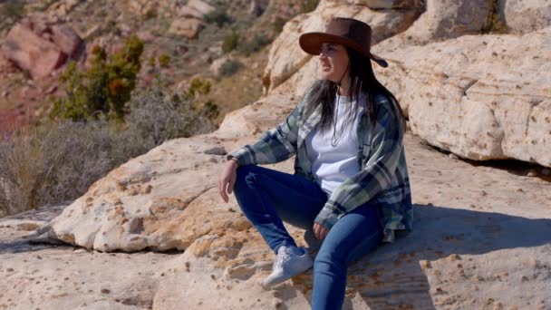 身着西式服装的年轻女子坐在内华达州的岩石上 旅行摄影 — 图库视频影像