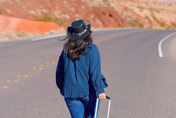 Mujer Joven Caminando Sola Por Desierto Con Una Maleta Como Imagen de stock