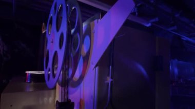 Sinema salonundaki bir sinema projektörünün içinden geçen 35 mm 'lik bir film. Bir sinemanın klasik film projektörü..