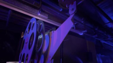 Sinema salonundaki bir sinema projektörünün içinden geçen 35 mm 'lik bir film. Bir sinemanın klasik film projektörü..