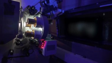Sinema salonundaki bir sinema projektörünün içinden geçen 35 mm 'lik bir film. Bir sinemanın klasik film projektörü..