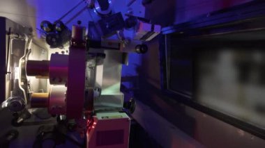 Sinema salonundaki bir sinema projektörünün içinden geçen 35 mm 'lik bir film. Klasik bir sinema projektörü. Sinemada projeksiyon odası