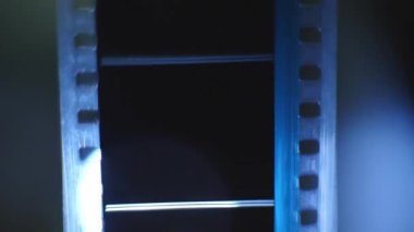 Bir sinemada 35 mm 'lik film şeridi. Bir filmin yakın çekim sahneleri.