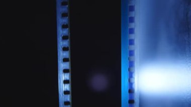 Bir sinemada 35 mm 'lik film şeridi. Bir filmin yakın çekim sahneleri.