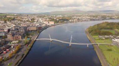 Derry şehri, nam-ı diğer Kuzey İrlanda hava manzaralı Londonderry Foyle nehrinin yukarısından güzel bir şehir güzel yaya barış köprüsüne ev sahipliği yapıyor.