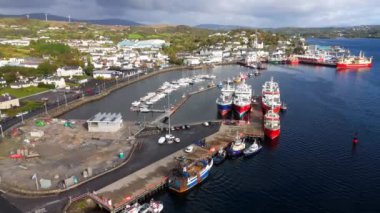 Killybegs, Donegal İrlanda 'da canlı bir liman, karamsar gökyüzünün altında huzurlu bir limana yanaşmış çok sayıda balıkçı teknesinin görüntülerini sunuyor.