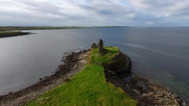 İrlanda 'nın batı kıyısındaki Donegal' daki St John 's Point' te tarihi bir harabe, sakin sular ve yemyeşil yeşillikler barındıran güzel ve sakin bir kıyı manzarası var.