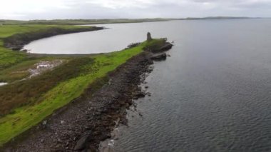 İrlanda 'nın batı kıyısındaki Donegal' daki St John 's Point' te tarihi bir harabe, sakin sular ve yemyeşil yeşillikler barındıran güzel ve sakin bir kıyı manzarası var.