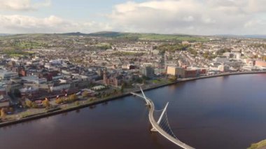 Derry şehri, nam-ı diğer Kuzey İrlanda hava manzaralı Londonderry Foyle nehrinin yukarısından güzel bir şehir güzel yaya barış köprüsüne ev sahipliği yapıyor.