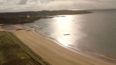 Donegal İrlanda 'da Fintra Körfezi - Güzel ve sakin bir sahil manzarası yumuşak kumları sergiliyor, yakınlarda yemyeşil yuvarlanan tepelerle birlikte