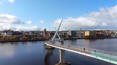 Derry şehri, nam-ı diğer Kuzey İrlanda hava manzaralı Londonderry Foyle nehrinin yukarısından güzel bir şehir güzel yaya barış köprüsüne ev sahipliği yapıyor.