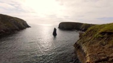 Malin Beg 'deki Donegal' in batı kıyısındaki FPV uçuşu - Resimli ve güzel manzaralı kıyı şeridi bereketli, yeşil tepeler boyunca sakin gök mavisi suları sergiliyor