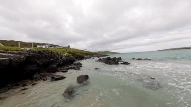 Malin Beg 'deki Donegal' in batı kıyısındaki FPV uçuşu - Resimli ve güzel manzaralı kıyı şeridi bereketli, yeşil tepeler boyunca sakin gök mavisi suları sergiliyor