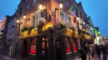 DUBLIN, IRELAND - 12 Ekim 2024 - Dublin Tapınak Bar Bölgesi - hareketli kalabalıklar ve canlı kentsel bir ortamda güzel aydınlatılmış binaların olduğu canlı bir tatil sahnesi