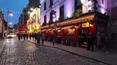 DUBLIN, IRELAND - 12 Ekim 2024 - Dublin Tapınak Bar Bölgesi - hareketli kalabalıklar ve canlı kentsel bir ortamda güzel aydınlatılmış binaların olduğu canlı bir tatil sahnesi