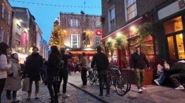 DUBLIN, IRELAND - 12 Ekim 2024 - Dublin Tapınak Bar Bölgesi - hareketli kalabalıklar ve canlı kentsel bir ortamda güzel aydınlatılmış binaların olduğu canlı bir tatil sahnesi