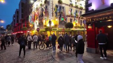 DUBLIN, IRELAND - 12 Ekim 2024 - Dublin Tapınak Bar Bölgesi - hareketli kalabalıklar ve canlı kentsel bir ortamda güzel aydınlatılmış binaların olduğu canlı bir tatil sahnesi