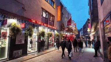 DUBLIN, IRELAND - 12 Ekim 2024 - Dublin Tapınak Bar Bölgesi - hareketli kalabalıklar ve canlı kentsel bir ortamda güzel aydınlatılmış binaların olduğu canlı bir tatil sahnesi