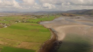 Güzel İrlanda - Uçsuz bucaksız, berrak mavi gökyüzünün altında sakin, yumuşak sularla buluşan kayalık kayalıkların nefes kesici manzarası