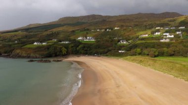 Donegal İrlanda 'da Fintra Körfezi - Güzel ve sakin bir sahil manzarası yumuşak kumları sergiliyor, yakınlarda yemyeşil yuvarlanan tepelerle birlikte
