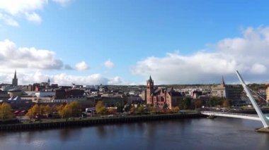 Derry şehri, nam-ı diğer Kuzey İrlanda hava manzaralı Londonderry Foyle nehrinin yukarısından güzel bir şehir güzel yaya barış köprüsüne ev sahipliği yapıyor.