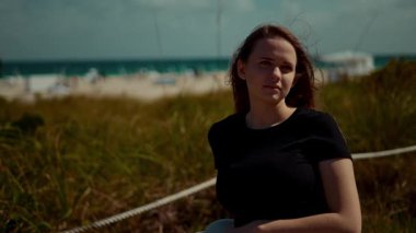 Şık ve şık bir genç kadın Miami Plajı 'nda poz veriyor, canlı yaz atmosferini ve modayı tamamen kucaklıyor.