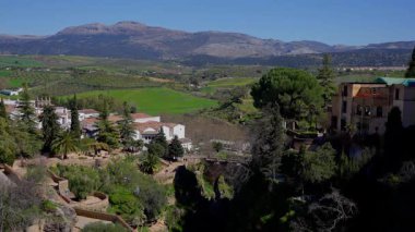 İspanya 'nın Endülüs kentinde popüler bir turizm merkezi olan El Tajo vadisine uzanan Puente Nuevo köprüsü ile Ronda şehir manzarası