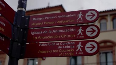 Sevilla 'daki kırmızı sokak tabelaları Metropol Şemsiyesi, La Anunciacion Kilisesi ve Lebrija Kontesi Sarayı' nın da aralarında bulunduğu ünlü eserleri gösteriyor - SEVILLE, SPAIN - 25 Mart 2025