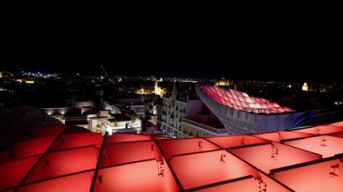 Metropol Şemsiyesi 'nin kırmızı ışıkları Sevilla' nın gökyüzünü aydınlatıyor, modern bir şehir manzarası yaratıyor - SEVILLE, SPAIN - 25 Mart 2025