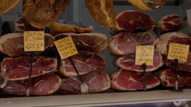 Süpürgeyle doldurulmuş kemiksiz İspanyol jambonu Serrano ve Iberico jambonu kasap dükkanında satılıyor.