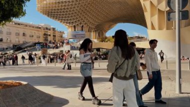 Arka planda Setas de Sevilla olarak da bilinen Metropol Şemsiyesi ile Plaza de la Encarnacion 'da yürüyen turistler - SEVILLE, SPAIN - 25 Mart 2025