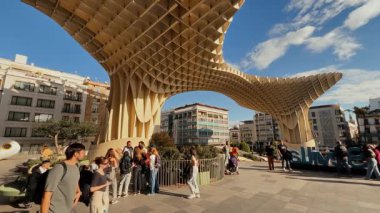 Dünyanın en büyük ahşap yapısı olan Sevilla, İspanya 'daki Metropol Şemsiyesi altında yürüyen turistler - SEVILLE, SPAIN - 25 Mart 2025