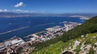Cebelitarık şehri, limanı ve Boğaz 'ın panoramik manzarası. Güneşli bir günde yelken açan kargo gemileri ve yolcu gemileri.