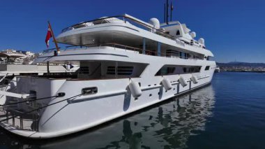 İspanya 'nın Marbella limanında demirli lüks beyaz yat, güneşli bir günde mavi gökyüzü - MARBELLA, SPAIN - 30 Mart 2025