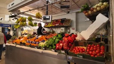 İspanya 'nın Cadiz kentindeki bir pazarda renkli meyve ve sebzeler düzenleyen manav - CADIZ, SPAIN - 26 Mart 2025