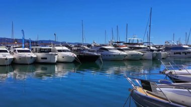 İspanya 'nın Marbella limanına demirlemiş beyaz lüks yatlar, güneşli bir günde Akdeniz' in sakin, mavi suyuna yansıyor - MARBELLA, SPAIN - 30 Mart 2025