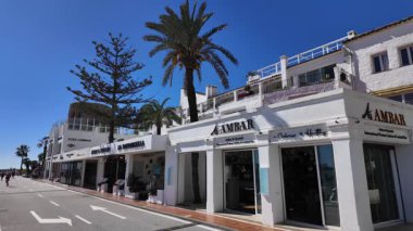 Şık mağazalar ve palmiye ağaçları Marbella 'da güneşli bir cadde, İspanya' nın Costa del Sol şehrinde popüler bir turizm merkezi - MARBELLA, İspanya - 30 Mart 2025