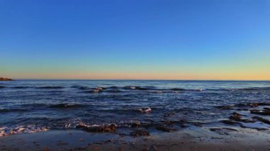 İspanya, Marbella 'nın kumlu sahillerini güzel bir günbatımında yıkayan küçük dalgalar.