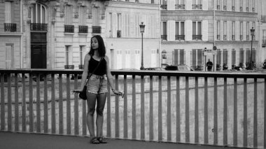 Genç turist Paris, Fransa 'daki bir köprüden kentsel manzaranın keyfini çıkarıyor