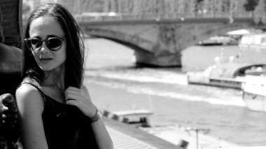 Paris, Fransa 'da Seine nehrinin yakınlarında poz veren zarif genç bir kadının siyah beyaz portresi.