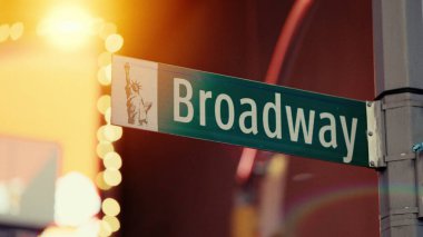 Arka planda Özgürlük Anıtı olan Broadway sokak tabelasını kapatın. Manhattan, New York 'ta yer alıyor.