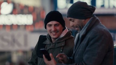 Manhattan, New York sokaklarında akıllı telefon kullanan iki adam.