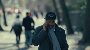 Manhattan, New York 'ta bir caddede yürüyen ve konuşan zarif bir işadamı.