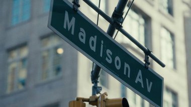 Manhattan, New York 'ta arka planı bulanık olan Madison Bulvarı sokak tabelasını kapatın.