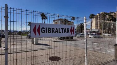 İspanya, La Linea de la Concepcion 'daki tel örgülerin arasından görünen Cebelitarık sınırını gösteren işaret levhası.