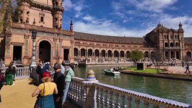İspanyol mimarisinin güzel bir örneği olan Plaza de Espana, Seville, İspanya 'da tekne turunun tadını çıkaran turistler, SEVILLE, SPAIN - 25 Mart 2025