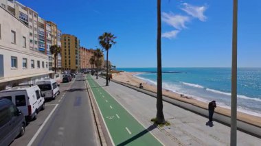 Güneşli bir günde Cadiz sahil şeridi, bisiklet yolu, sahil ve konut binalarını gösteren manzara, İspanya - CADIZ, SPAIN - 26 Mart 2025